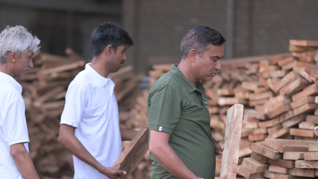Staff inspecting kiln-dried timber stock in the Wood Factory yard